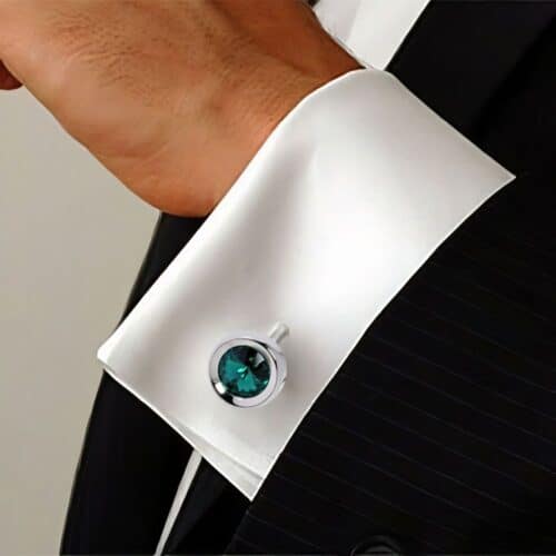 AryA Gioielli | Altarocca gemelli uomo tondi con cristallo Swarovski verde - 216AB - su sfondo polsino camicia bianca con abito nero